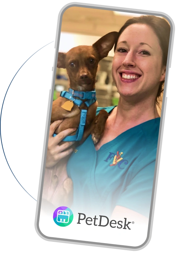 Smiling veterinary staff member holding a small brown dog, displayed on a phone screen with the PetDesk app logo